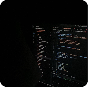 Laptop with code on the screen in a dark room